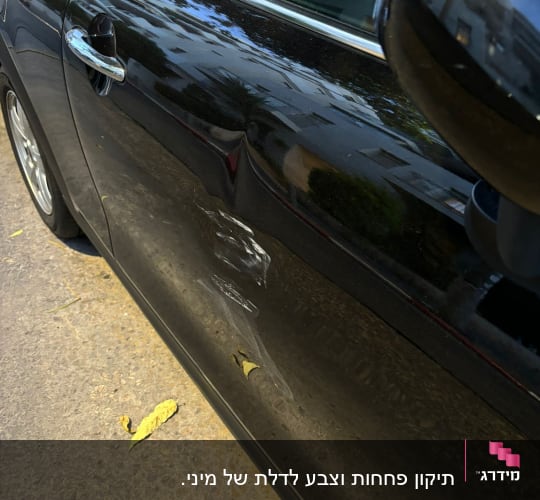 נזק לדלת רכב שחורה עם שריטות ושקעים